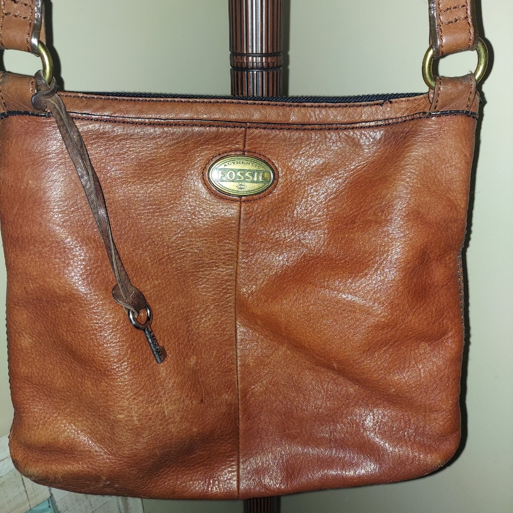 Fossil brown leather crossbodyoag with multiple compartments adjustable strap.